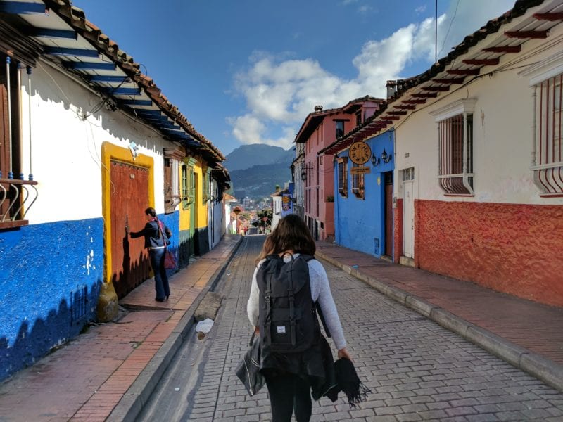 A backpacker walks by a healthcare clinic in Colombia