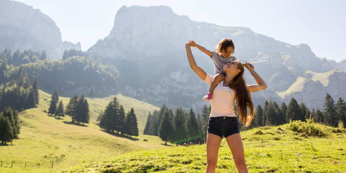 a mum holding her child in front of the Swiss Alps in Switzerland, one of the best places to raise a family in 2025