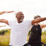 a smiling man enjoying an outdoor yoga class in one of the healthiest countries in the world