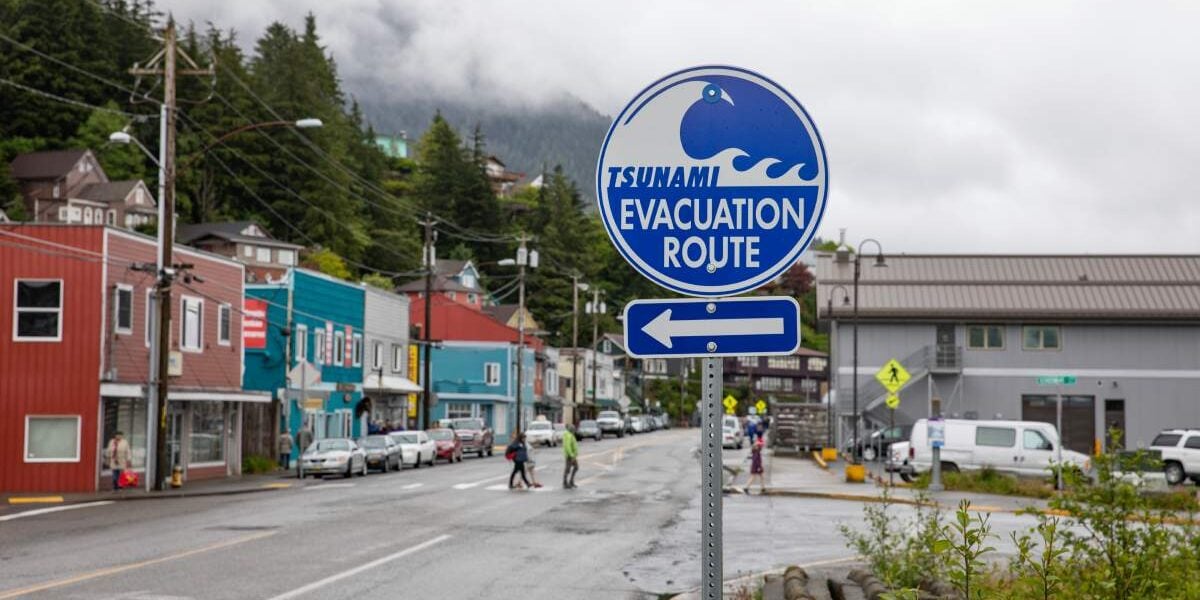 an earthquake tsunami evacuation sign in Japan, where tourists are advised to buy natural disaster insurance 