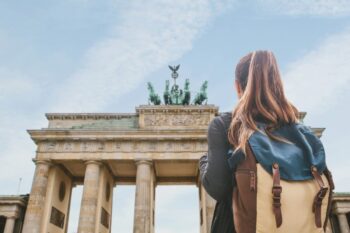 a female tourist looking at the Brandenburg Gate in Berlin, having bought travel insurance for Germany
