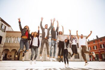 a group of students jumping in the air during a trip to Italy