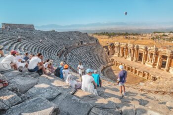 a group of students visiting Hierapolis Amphitheater in Turkey, having secured student group travel insurance before the trip