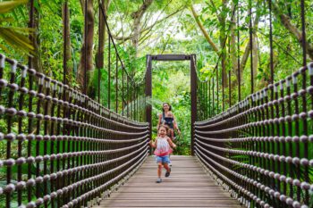 mom and two children walking through a garden in singapore