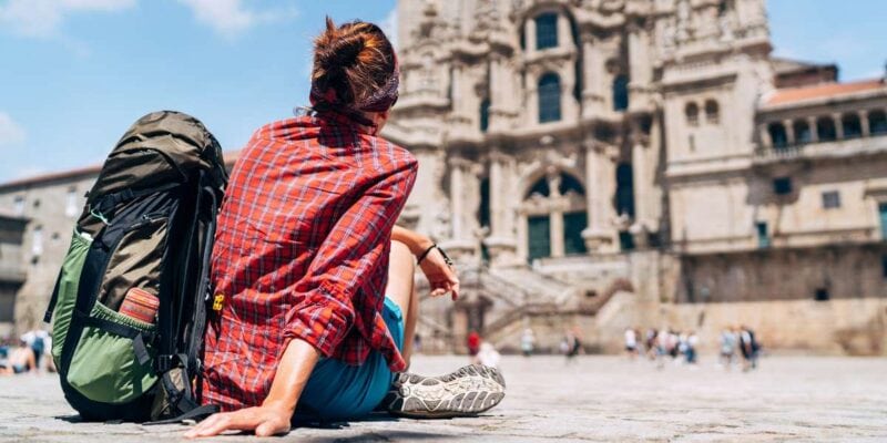 a female backpacker admiring the Cathedral of Santiago de Compostela in Spain, one of the European countries you need a Schengen visa for