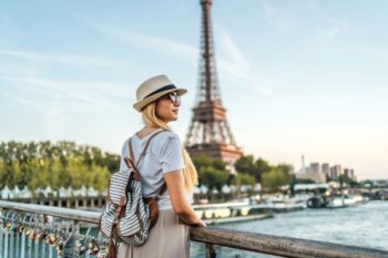 a woman admiring the Eiffel Tower in Paris, having purchased travel insurance for France