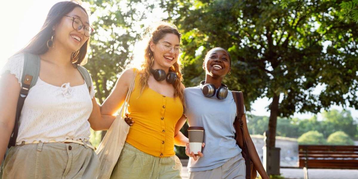 An international student socializing with two local students outdoors on campus, sharing and exchanging study abroad tips