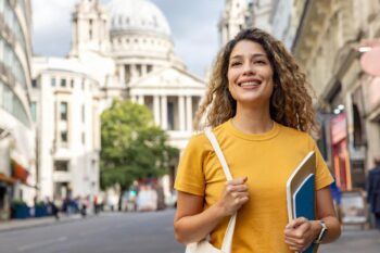 A happy student walking in the streets of London, feeling confident after reading essential study abroad tips