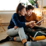 a couple planning where to go on vacation during hurricane season, while researching hurricane travel insurance