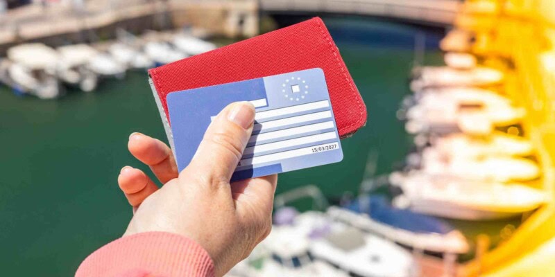 a hand holding European Health Insurance Card (EHIC) which can be used in addition to travel insurance for Portugal