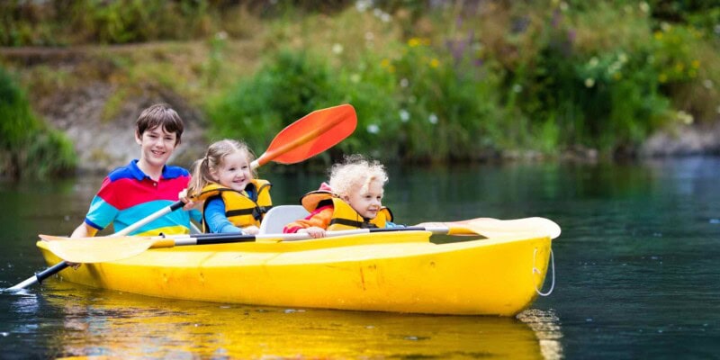 kids in a kayak in Canada, one of the best countries to move to from the USA with family