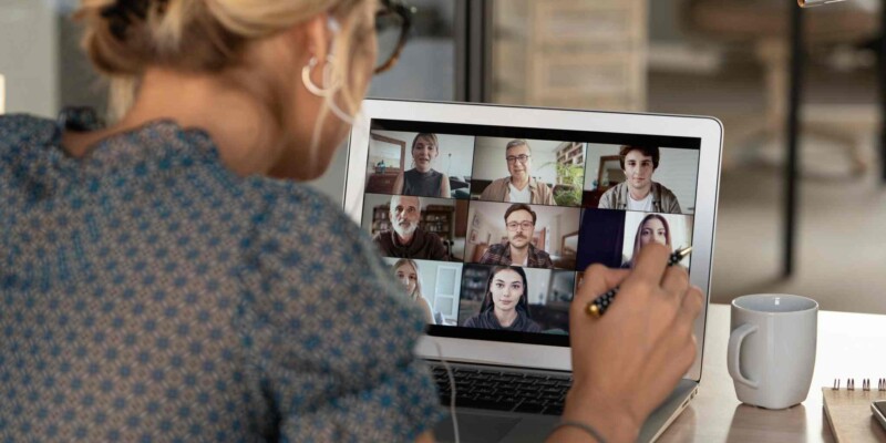 a woman on a zoom call with her colleagues, having read our tips on how to manage a remote team