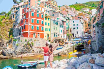 a happy couple exploring Riomaggiore in Italy, one of the best travel destinations in 2025