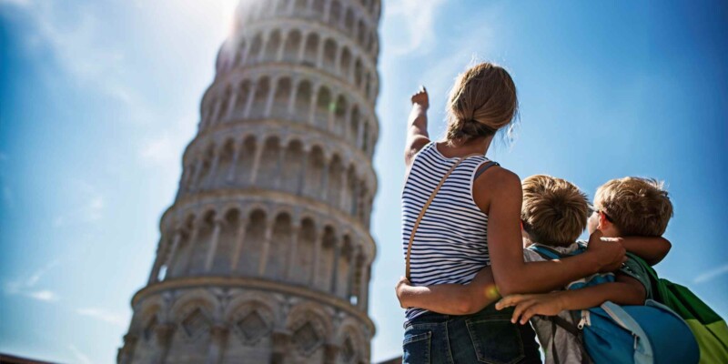 a mother with her two children at the Leaning Tower of Pisa in Italy, ones of the best travel destinations in 2025