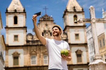 a happy tourist taking a selfie in Salvador, Bahia, after buying travel insurance for Brazil