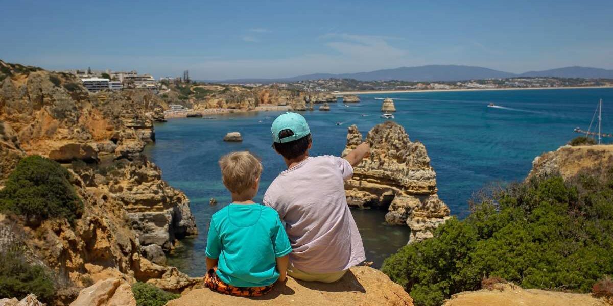 A family sitting by the coast in Greece, one of the best family vacations ideas for 2025