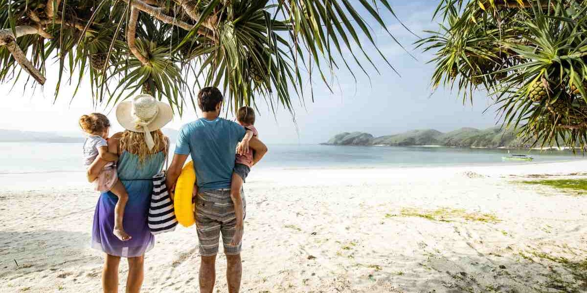a family walking on a beach on Nikoi Island in Indonesia, one of the best family vacation ideas for 2025