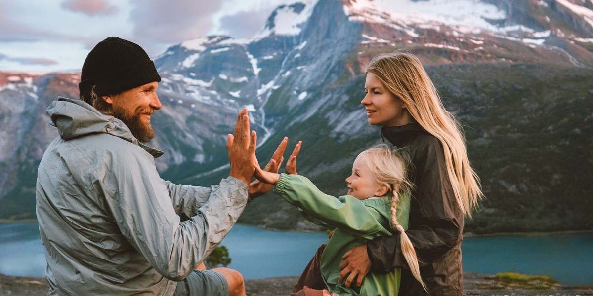 a mother, father and child sitting overlooking the mountains in Norway, one of the healthiest countries in the world