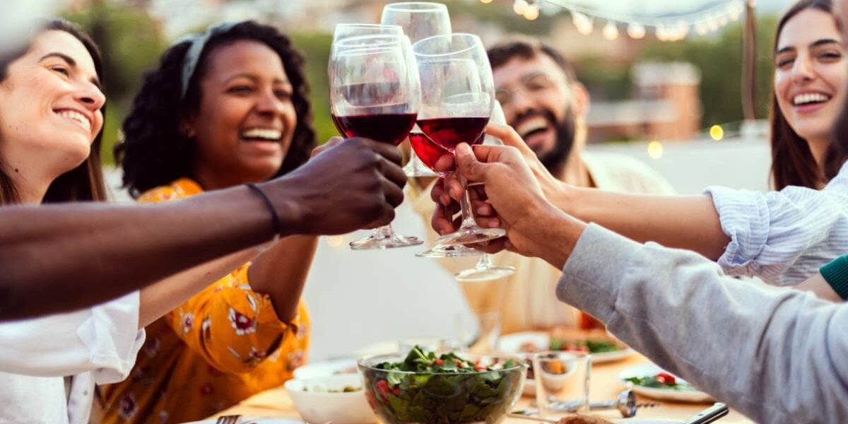 a group of friends smiling and drinking red wine in Spain, one of the healthiest countries in the world