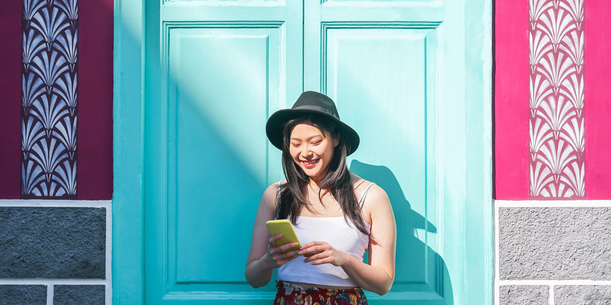 a happy girl using an app to manage her money, one of our top study abroad tips for students