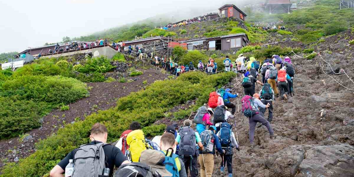 hikers climbing Mount Fuji in Japan, highlighting the important of purchasing travel insurance for Japan