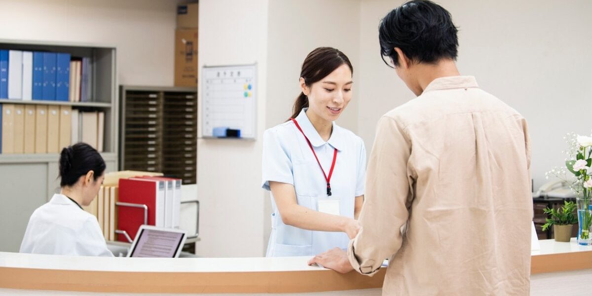 a man paying a medical bill at a Japanese hospital, highlighting the important of securing travel insurance for japan