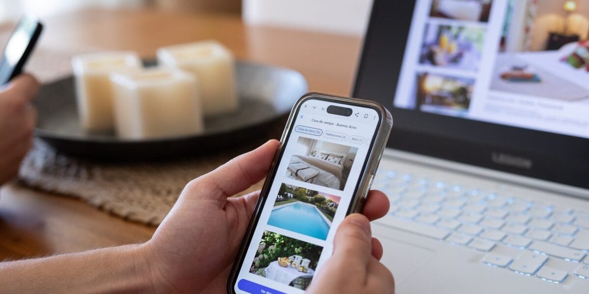 a person viewing hotel listings on an app on their smartphone, one of the prime targets of travel scams