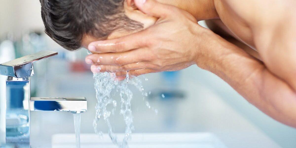 a man washing his face and keeping it clean from pollution, one of the best skin care tips for living abroad