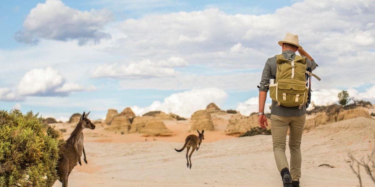 a man hiking in the Australian outback, having secured travel insurance for Australia before taking his trip