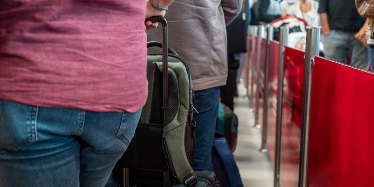 a traveler waiting in line at passport control to show his passport and ETIAS for entry into Europe