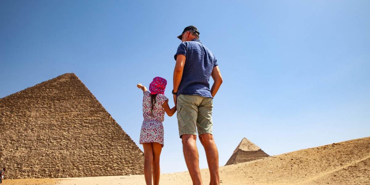 a father and daughter looking at the pyramids in Cairo, one of the best family vacation ideas for 2025