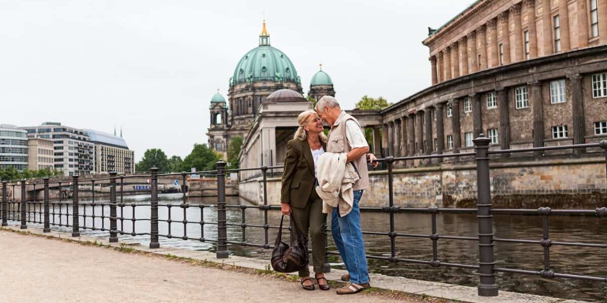a senior couple standing in front of Berlin Cathedral, having bought travel insurance for Germany