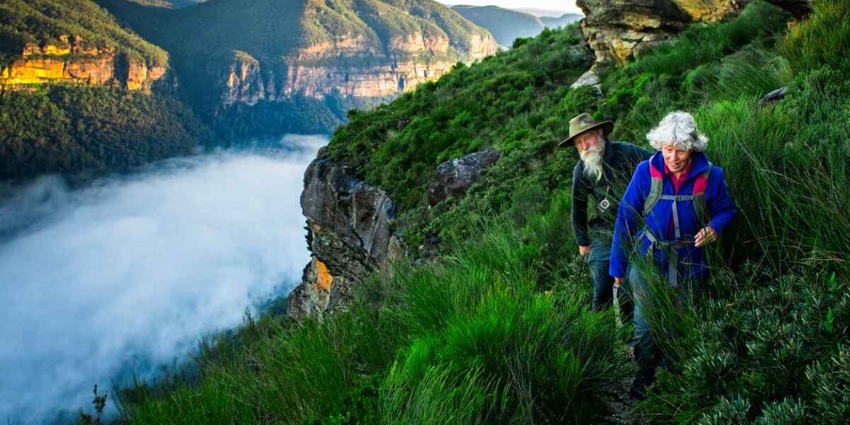 a senior couple hiking in the Australian mountains, highlighting the important of buying travel insurance for Australia