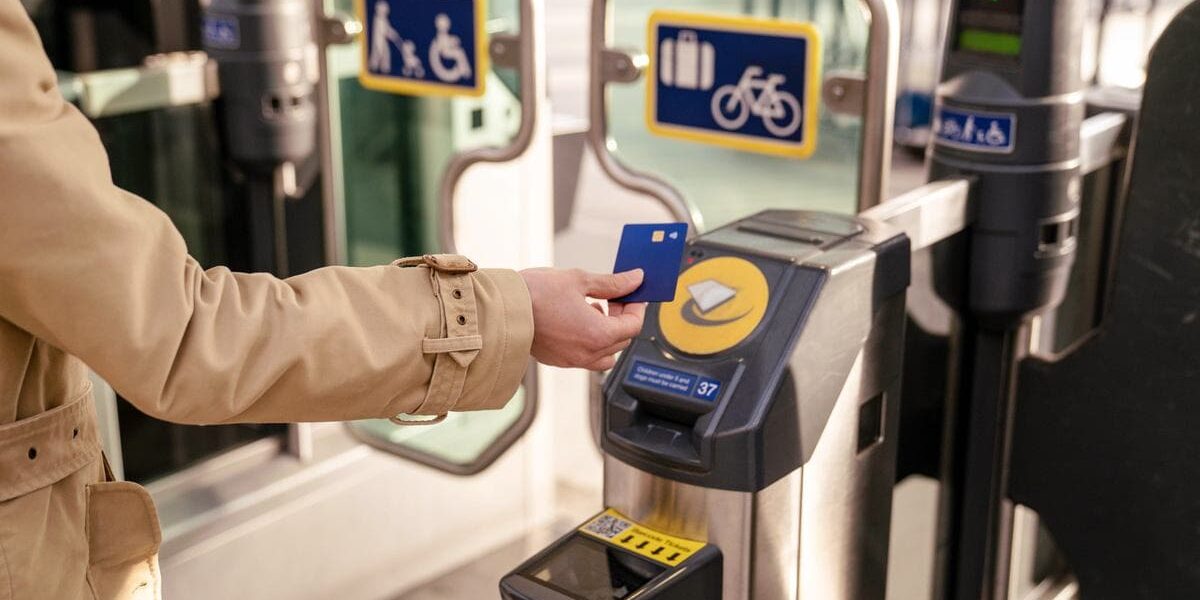 a woman using card for getting through ticket barrier in London, where tourists are advised to buy UK travel insurance
