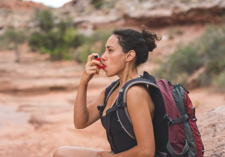 woman experiencing acute onset of pre-existing asthma condition while hiking
