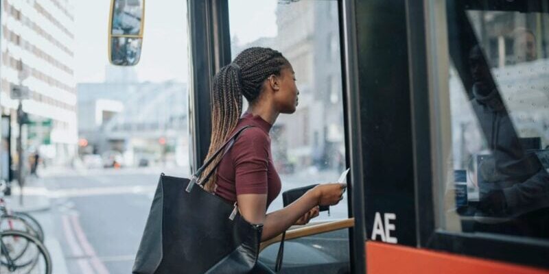 a woman boarding a bus in a new city, after becoming an expat