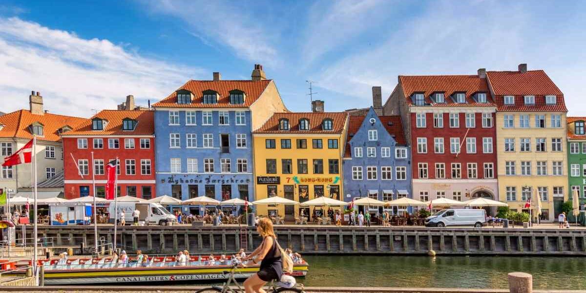 a woman cycling a bike in Copenhagen, one of the best countries to live in as an expat