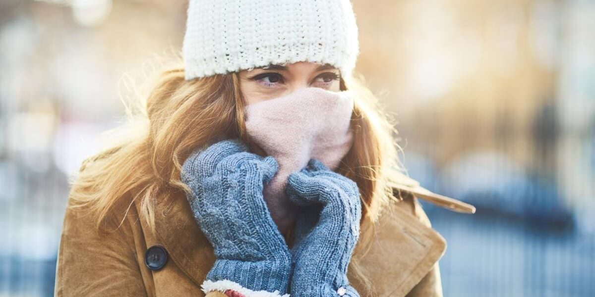 a woman wrapped up warm in a snowy city, protecting herself after reading our expert skin care tips for living abroad